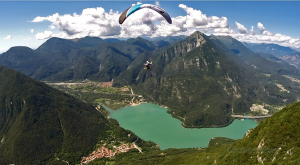 Parapendio in volo sulle acque del lago dei Tre Comuni in Friuli